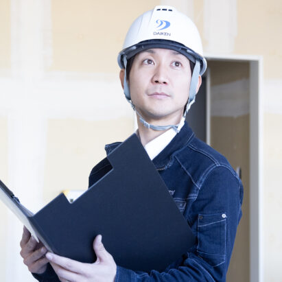 真剣な眼差しで施工している建築現場の内観を確認していく男性従業員